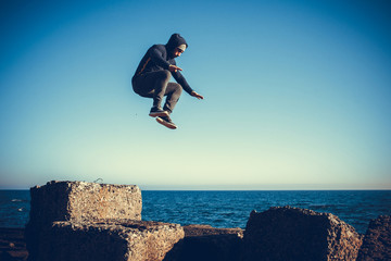 man performs freerunning jump on stones