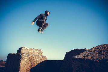 man performs freerunning jump on stones