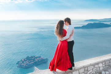 Romantic young couple in love over sea shore background. Fashion