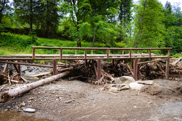 The destroyed bridge through the mountain river, the Carpathians