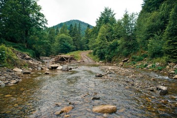 Broken bridge on the mountain river in the Carpathians, Ukraine