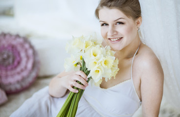 Obraz na płótnie Canvas Pregnant woman smiling with bouquet of daffodils