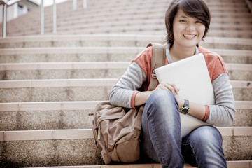Obraz premium attractive female college student sitting on stairs