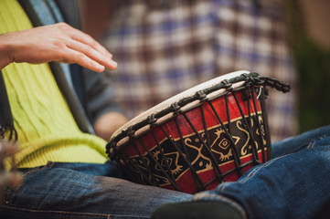 person playing on Jambe Drum no face