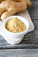 Fresh ginger root with powder on a cutting board