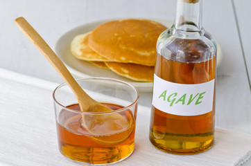 Agave syrup and a plate of pancakes.