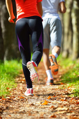 Jeune couple jogging dans le parc au matin. Santé et remise en forme.