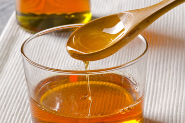Agave syrup pouring on a glass.