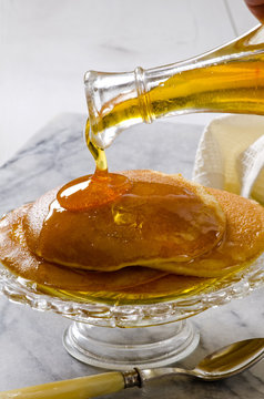 Agave syrup pouring on a plate of pankakes.