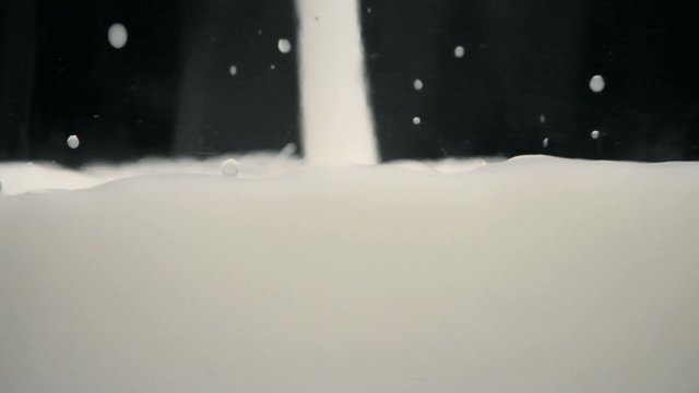 Milk pour into a glass, closeup