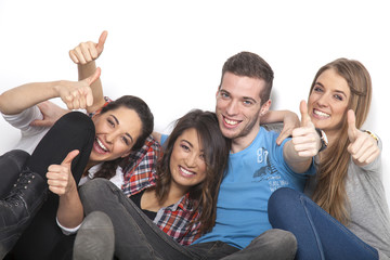 Vier Freunde unterschiedlicher ethnischer Kulturen halten ihre Daumen hoch