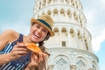 Portrait of happy woman with pizza in front of tower of pisa