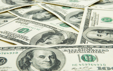 One hundred dollars pile as background.