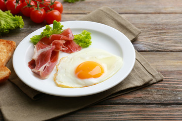 Bacon and eggs on rustic wooden planks background