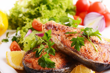 Tasty baked fish on plate close-up