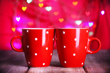 Two red cups on table on lights background