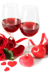 Composition with red wine in glasses, red roses, ribbon and