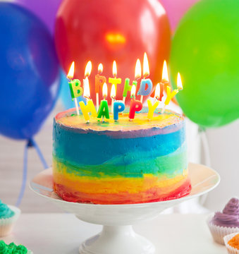 Rainbow Cake And Cupcakes Decorated With Birthday Candles