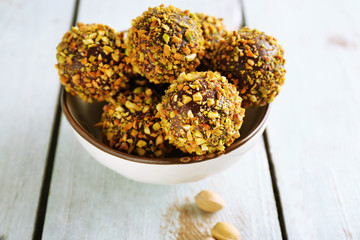 Tasty homemade pistachio candies on wooden table