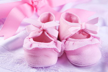 Pink baby boots on cloth close-up