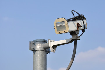 Damaged security camera case mounted with pole.