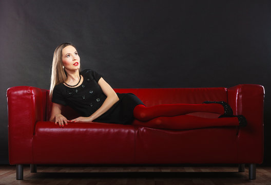 Fashion woman in red pantyhose on couch