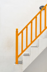White vintage stairs with yellow banisters.