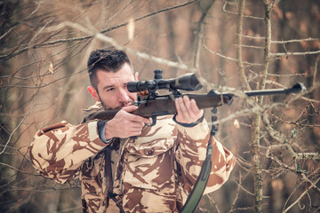 Fototapeta premium Man holding a sniper and shooting on an open season