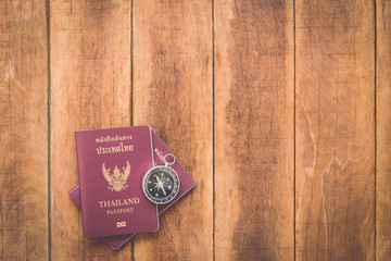 Thailand passport and compass on wood