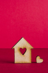 Wooden house with hole in the form of heart with little heart on