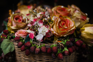 Artificial flowers in the basket over black background