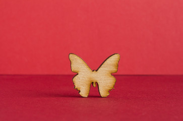 Wooden icon of butterfly on red background