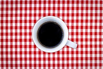 A cup of black coffee on a chess background