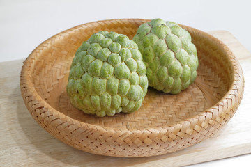 two sugar apples in basket with white background