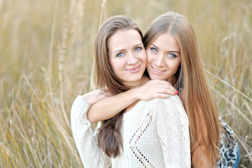 Obraz premium portrait of two beautiful sisters in the autumn
