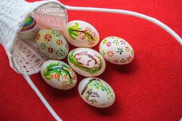 Easter eggs in basket on color background