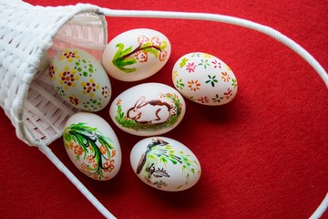 Easter eggs in basket on color background