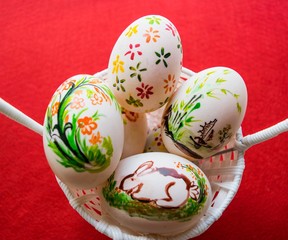 Easter eggs in basket on color background