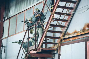 three soldiers climb the stairs at the factory