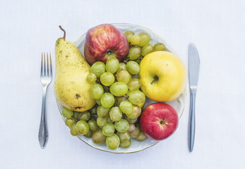 Plate full of natural fruits - grapes, apple, pear