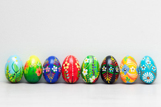 Hand-painted Easter eggs on white rustic wall. Spring patterns