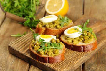 Fototapeta na wymiar Sandwiches with green peas paste and boiled egg with herbs and
