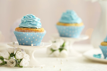 Delicious cupcakes on table on light background