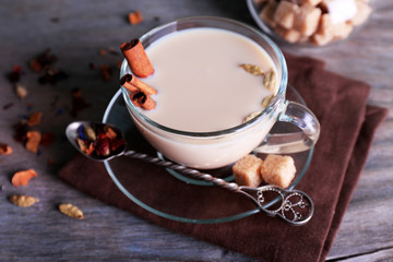 Black tea with milk and lump sugar and spices  in glassware