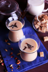 Black tea with milk and lump sugar and spices  in glassware