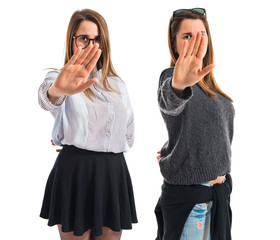 Twin sisters making stop sign