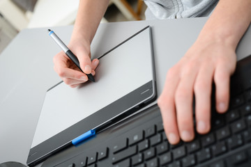 close up hands working with graphic tablet and keyboard