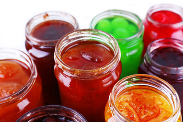 Fototapeta na wymiar Homemade jars of fruits jam on color table background