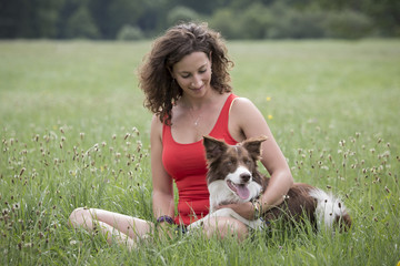 Hund und Frau auf einer Wiese