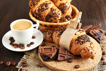 Fresh and tasty croissants with chocolate and cup of coffee